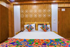 a bedroom with a large bed with a colorful comforter at FabExpress Sapphire in Mussoorie