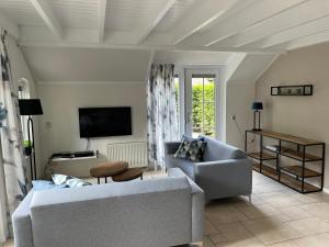 a living room with a couch and a tv at Villa Clementine with sauna in Ermelo in Ermelo