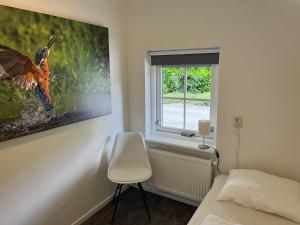 a bedroom with a picture of a bird on the wall at Villa Clementine with sauna in Ermelo in Ermelo