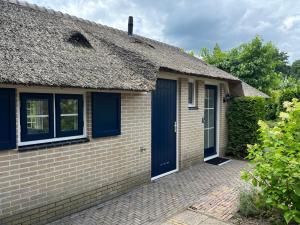 a brick house with a blue door and windows at Villa Clementine with sauna in Ermelo in Ermelo