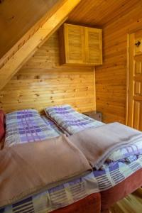 un letto in una stanza di legno con soffitta di Guest House MIKA a Žabljak