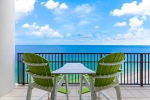 una mesa y 2 sillas en un balcón con vistas al océano en The Oasis at Orange Beach Condos by Hosteeva en Orange Beach