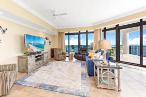 a living room with a couch and a tv at The Oasis at Orange Beach Condos by Hosteeva in Orange Beach
