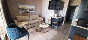 2SIX2 On Florida Road, Modern Lifestyle apartment 802 في ديربان: غرفة معيشة صغيرة مع أريكة وطاولة