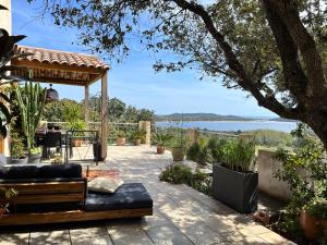 a patio with a couch and a gazebo at Kallinera in Porto-Vecchio
