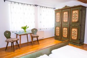 聖米歇爾隆高的住宿－Hotel Weissenstein，一间卧室配有桌子、两把椅子和一张床