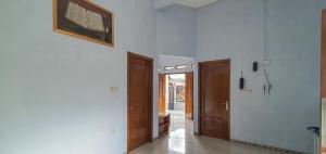 a room with two doors and a hallway with at Griya Mbak Tafik Syariah in Gendingan