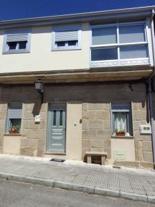 un edificio con una puerta y un banco delante de él en Casa Cea Ourense, en Cea