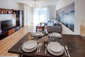 コウォブジェクにあるVacationClub - Diune Apartment 27のリビングルーム(白い皿と銀製品付きのテーブル付)