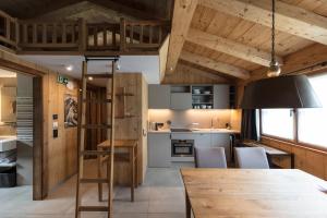 a kitchen and dining room with a loft bed at ArlBerglife Ferienresort in Pettneu am Arlberg