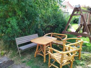 a wooden table and two chairs next to a bench at Gästehaus in der Friedensfabrik in Wanfried