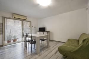 uma sala de estar com uma mesa e cadeiras e um sofá em Solelio em Alghero