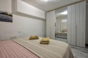 a bedroom with a bed with two towels on it at Solelio in Alghero