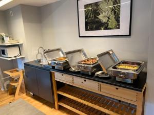 a buffet with four trays of food on a table at Hotell Angöringen in Karlskrona