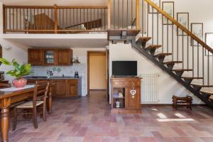 cocina y sala de estar con escalera y mesa en Vernaccia Country house en Tavarnelle in Val di Pesa