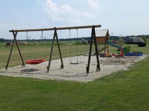 eine Schaukel in einem Park mit Spielplatz in der Unterkunft tHoefijzer Luxere Blokhutten 5 pers en Mini Camping in Zwiggelte