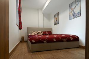 Bett in einem Zimmer mit einer roten Decke in der Unterkunft Chalet 5 Laghi / LuxApt / Town Centre in Madonna di Campiglio