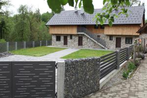 a house with a fence in front of it at Mulina River Lodge in Pribanjci