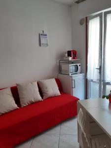 ein rotes Sofa im Wohnzimmer mit Mikrowelle in der Unterkunft Aria in Porto Santa Margherita