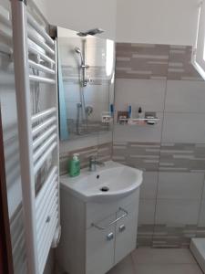 ein weißes Bad mit einem Waschbecken und einer Dusche in der Unterkunft Aria in Porto Santa Margherita