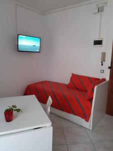 Zimmer mit einem Bett mit einer roten gestreiften Decke in der Unterkunft Aria in Porto Santa Margherita