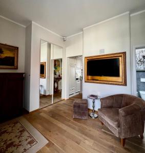 a living room with a couch and a television on a wall at Schottennester Schlafen an der Krämerbrücke in Erfurt