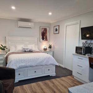 una camera con letto bianco e TV di Kadi House - Unit 2 a Wynyard