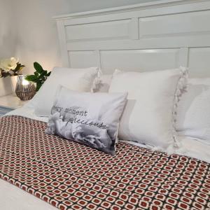 a pillow sitting on a bed with white pillows at Kadi House - Unit 2 in Wynyard
