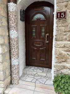 uma porta de madeira num edifício de pedra com uma placa em Boutique House Belevi em Nessebar