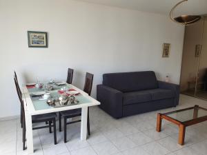 a living room with a table and a couch at Royal Palm Juan les pins -Appartement 53M2 avec terrasse ensolleillée 5e dernier étage 200m de la plage in Juan-les-Pins