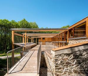a wooden walkway leading to a building with a stone wall at Abeiro da loba in Madelos