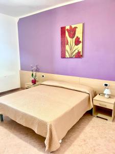 a bedroom with a bed with a purple wall at Vacanze Da Annalisa in Centola