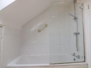 a white bathroom with a shower and a tub at Seaview in Weymouth