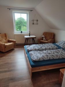 a bedroom with a bed and two chairs and a window at U Petíse in Horní Blatná