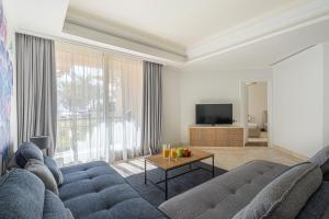 a living room with a blue couch and a television at HiGuests - Luxurious 1BR in Palms with Private Beach Access in Dubai