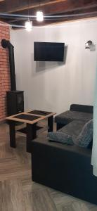 uma sala de estar com uma mesa e um sofá em Agroturystyka Na górce u Barbary - domek letniskowy em Lesko