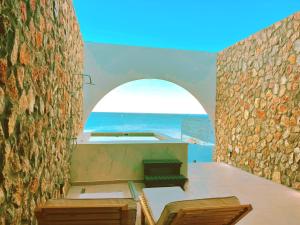 a view of the ocean from the balcony of a house at Delfini Beach Hotel & Suites in Archangelos