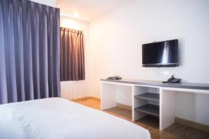a hotel room with a desk with a tv on it at Vanilla Residence Chiangmai in Chiang Mai +17 photos