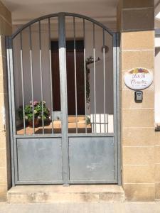 uma porta de metal com dois vasos de plantas por trás em B&B Ornella em Leverano