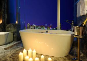 a bathroom with a tub with candles and wine glasses at Rhombus Park Aura Chengdu Hotel in Chengdu