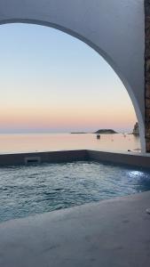 a swimming pool with a view of the ocean at Delfini Beach Hotel & Suites in Archangelos