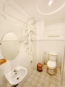 La salle de bains est pourvue de toilettes, d'un lavabo et d'un miroir. dans l'établissement HOTEL Bồ Câu, à Cần Thơ