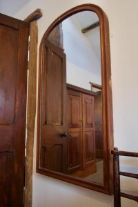 a mirror with a wooden door in a room at The Pavement Palace in Hay-on-Wye