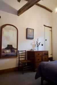 a bedroom with a mirror and a bed and a dresser at The Pavement Palace in Hay-on-Wye