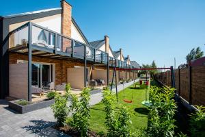 a house with a glass bridge over a yard at Domki Premium LATO&ZIMA z basenem in Dębki