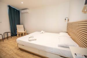 sypialnia z dużym białym łóżkiem i krzesłem w obiekcie Montgolfiere Apartment by Connexion w Cannes