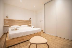 sypialnia z białym łóżkiem i krzesłem w obiekcie Montgolfiere Apartment by Connexion w Cannes