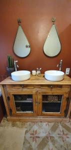 two sinks on a wooden vanity with two mirrors at Maison campagne chic in Biganos +5 photos