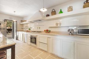 eine große Küche mit weißen Schränken und Geräten in der Unterkunft Villa La Pajara in Santa Maria di Leuca