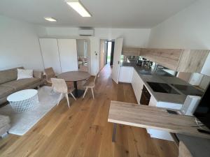 una cucina e un soggiorno con tavolo e divano di 25h SPA-Residenz BEST SLEEP privat Garden & POOLs a Neusiedl am See